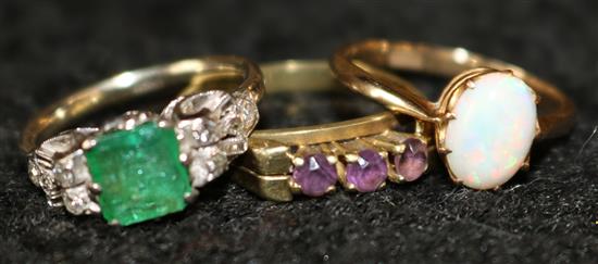 9ct gold opal ring, a similar three stone amethyst ring and an emerald and diamond ring